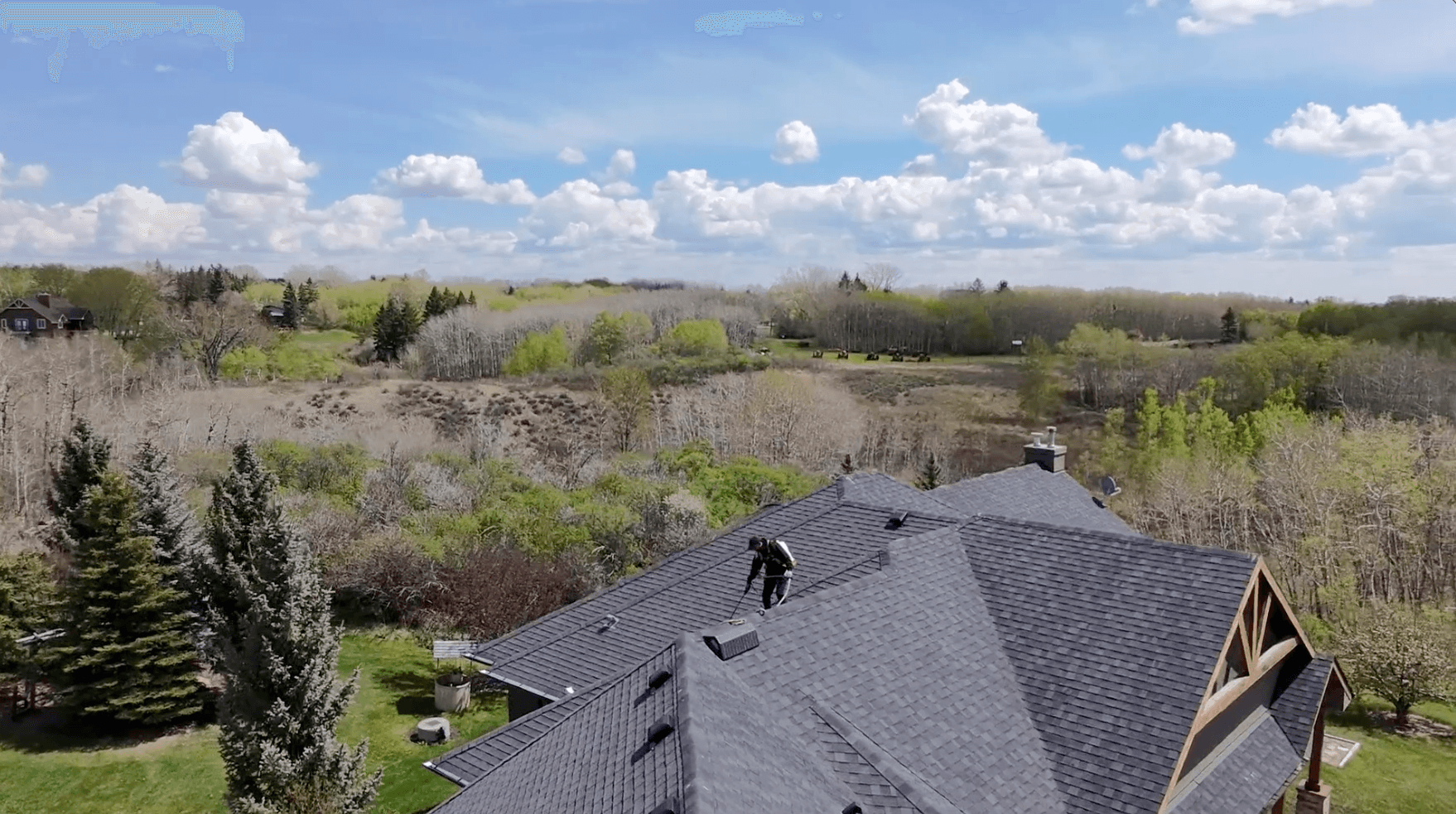 Nanoclad technician applying roof protection treatment on a residential shingle roof